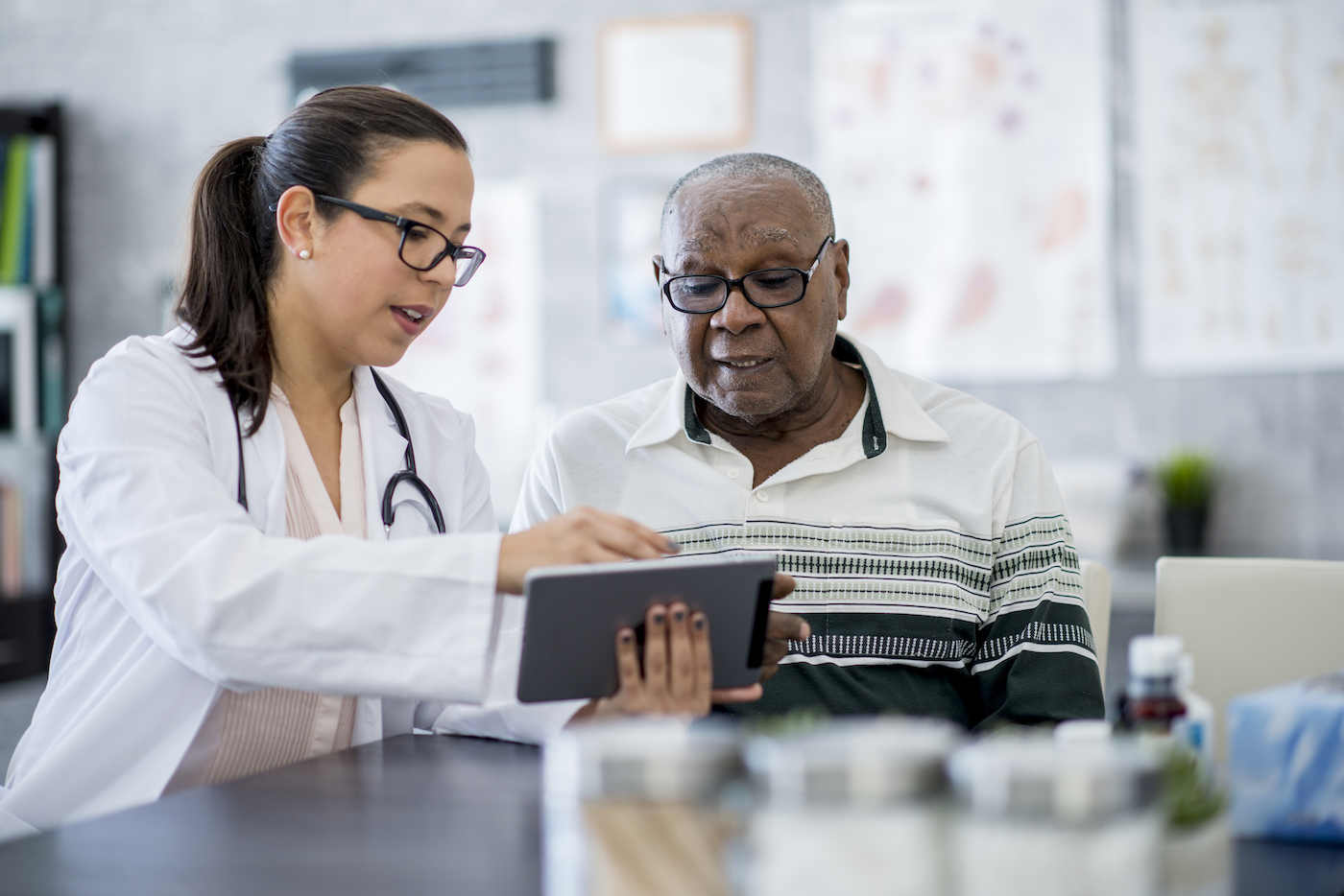 Doctor With A Tablet Computer Doctor sharing information on tablet computer with patient inside doctor's office