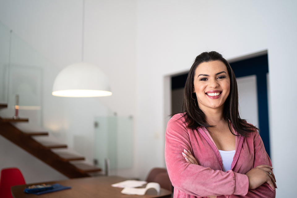 trans_woman Woman in pink top standing at wooden table